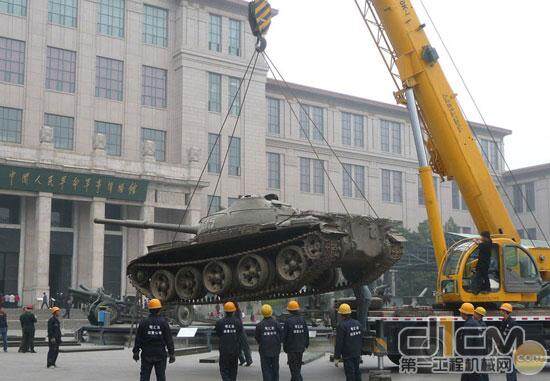 工人正在吊卸一辆从军博东、西兵器广场运来的坦克