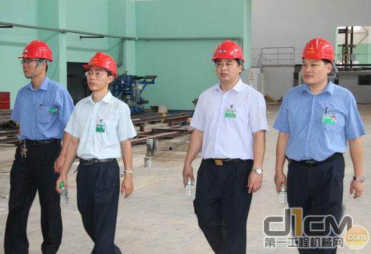 何晓宇(右)一行在筹建中的铸造二车间听取铸造厂文化基地建设汇报