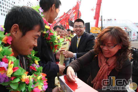 徐冲董事长和沈闵女士为购机客户献上挖机模型、金钥匙、花环