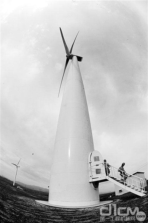 两名金风科技测试人员在乌鲁木齐达坂城的一处风力发电场内检测金风科技生产的一台风机