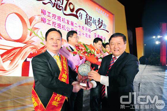 图为王晓华董事长在挖掘机十周年庆典晚会上给供应商颁发“十年合作奖”。