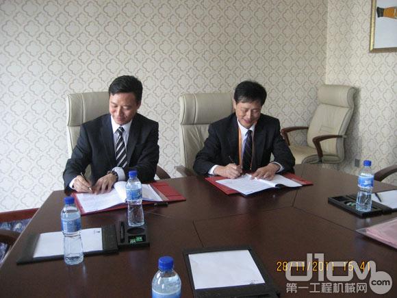维佳总经理雷立昌（左）与厦工小型机事业部常务副总经理俞久仁大笔一挥，双方正式结成战略合作伙伴。