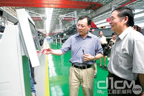 三一集团总裁唐修国(左一)向客人介绍三一的制造执行系统(MES)