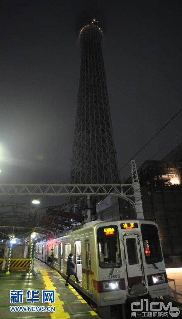 2月29日，在日本东京，乘客在乘坐电车，远处是世界最高的电视塔“东京天空树”。