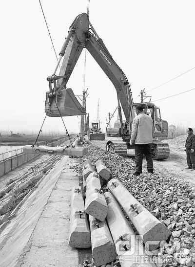  3月12日，汉宜铁路施工人员通过机械将已经铺设好的铁路枕木吊离路基，以便重新施工。