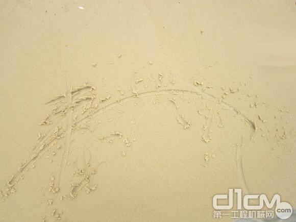 秦兴权在沙滩书写自己的名字，将豪情与美好记忆铭刻在三亚。