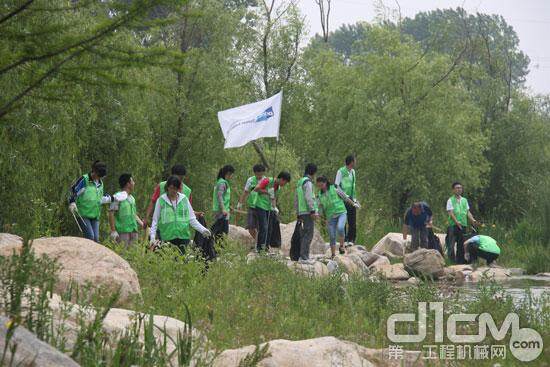 志愿者在绿化树林中捡垃圾