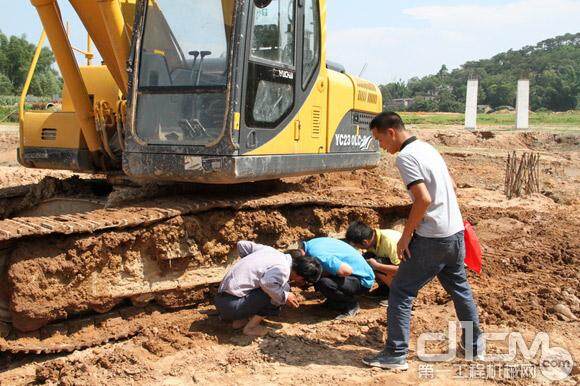广西区域服务经理陶仁安（左一）为桂平石龙段工地参与施工的玉柴挖掘机检点