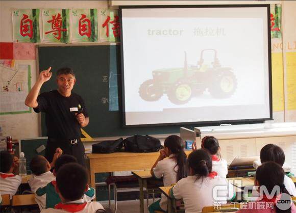 约翰迪尔中国总裁刘镜辉正在教学生们英文单词