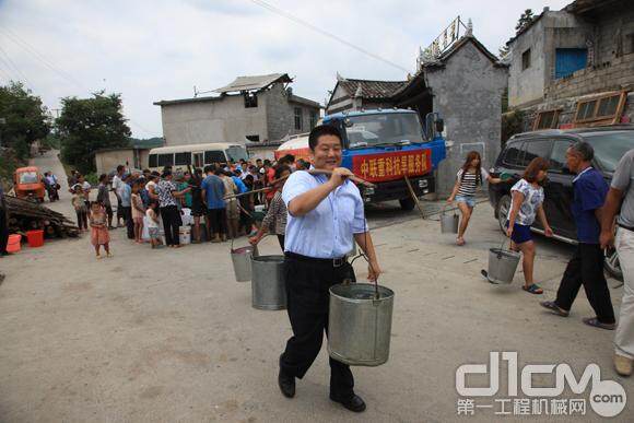 中联重科工作人员帮助村民担水