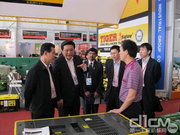 图为韩九云副市长（左二）在常柴展位前了解产品出口情况
