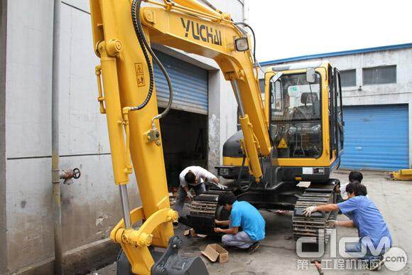 玉柴重工工作人员正为叶老板订购的YC60-8挖掘机装配橡胶履带