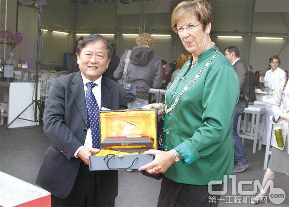 图为王晓华董事长向阿尔默勒市市长安娜玛丽·约里斯玛女士赠送礼物