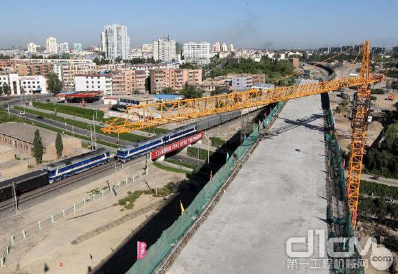 8月1日，两列火车从建设中的兰新高铁新疆哈密立交特大桥边驶过