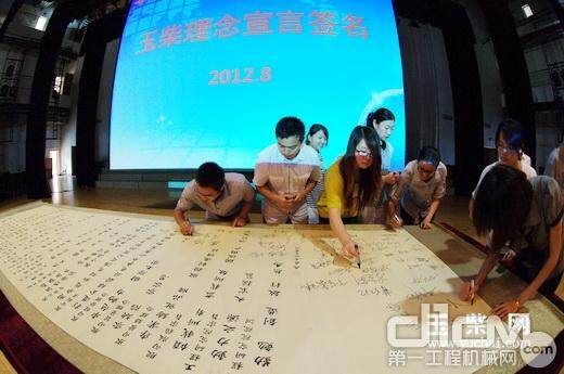 新员工代表纷纷在写满玉柴文化理念的书法作品上签名