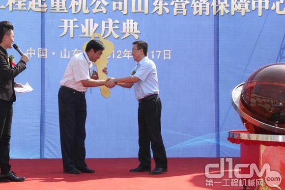 山东保障中心副总经理刘旭龙将象征中联的金钥匙交到华通石化的孙总手中