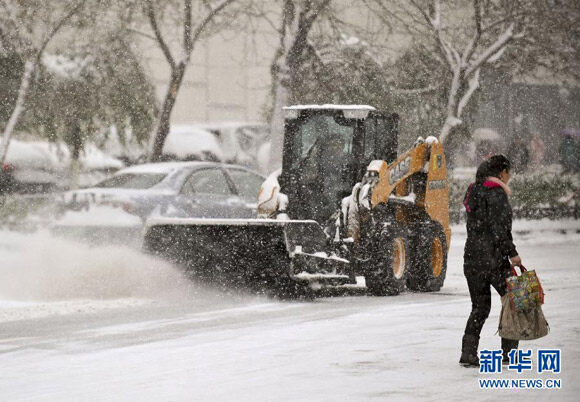 新华网报道凯斯滑移装载机配备斜角扫雪器应用于新疆城市道路清雪