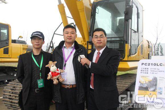 中间的这位是来自上海的杨先生，他在今天的新品发布会上预定了小松新发布的PC200-8M0挖掘机，右边的是小松(中国)代理店业务部韩东副部长