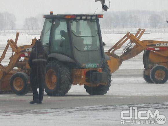 在哈尔滨太平国际机进行清雪作业的凯斯挖掘装载机