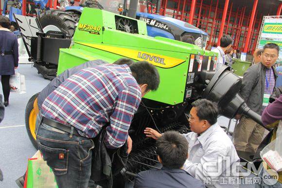 雷沃工作人员向客户介绍雷沃打捆器