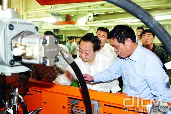 高级总裁殷正富（右一）向全国政协常委李毅中(左一)介绍混凝土拖泵。