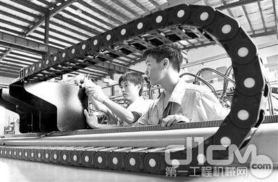 工人在河北邢台经济开发区创力机电科技有限公司组装数控直条切割机