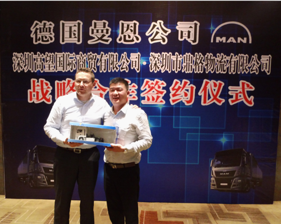 图为曼恩商用车中国总裁 Thilo Halter先生（左）向深圳鼎格物流有限公司董事长胡刚志先生（右）赠送车模，并对双方的合作给予了充分肯定。