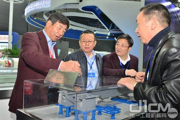 中国铁建董事长孟凤朝（左一）与铁建重工董事长刘飞香（左二）就中低速磁浮道岔工作原理进行交流