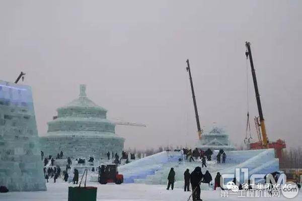 两台徐工起重机正在为一座城堡做最后塔顶的搭建