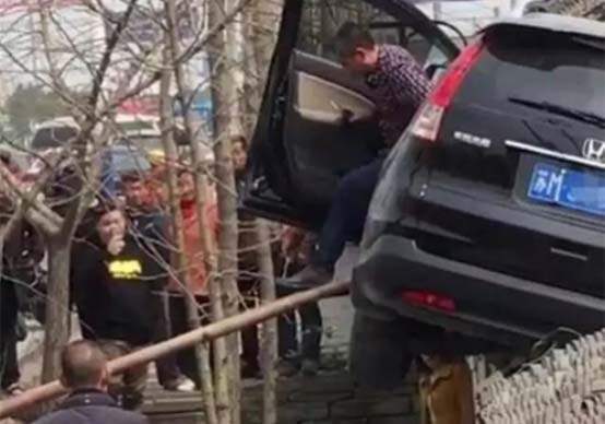 ▲交警赶到事故现场，借了一条梯子让车主爬下来。