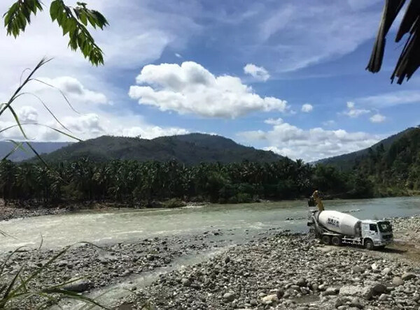 徐工混凝土拖泵及搅拌车正在联合参建当地某公路大桥项目