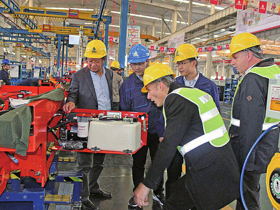 “临工重机”总经理支开印（左一）陪同意大利客户参观高空作业机械系列产品。