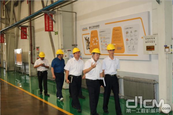 在雷沃工程机械副总经理王金华的陪同下，中国砂石协会会长胡幼奕深入生产车间