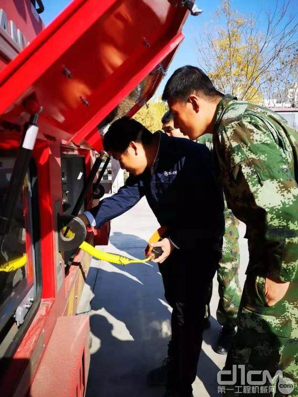 黄滢恒在现场给消防官兵做臂架泵管余水处理讲解