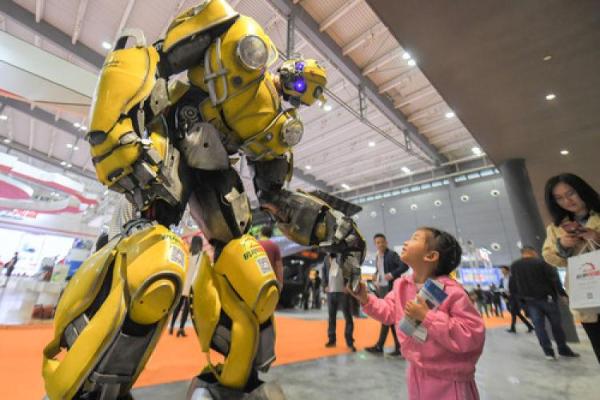 5月15日，在长沙国际工程机械展览会上，小朋友和机器人互动。新华社发(陈泽国摄)