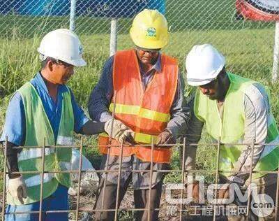 中国工人在圭亚那德莫拉拉东海岸道路升级改造项目向圭亚那工人讲解技术要领