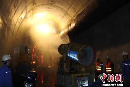 图为工人进行隧道喷雾养护