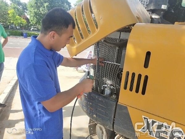 服务工程师在为客户挖机清洗着空调散热系统