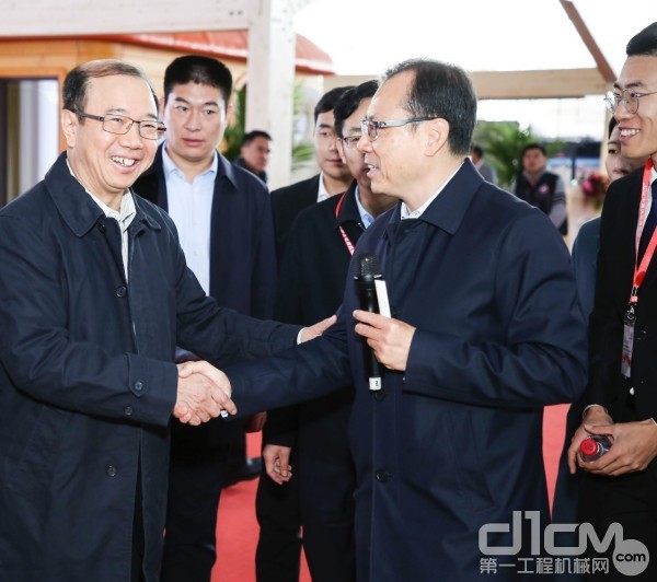 图|住建部副部长易军（左1）与唐修国总裁（右2）在三一筑工展台亲切交谈
