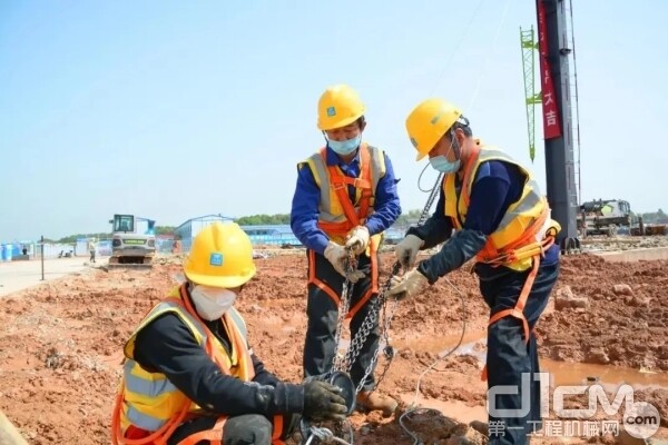 钢结构首吊完成后，工人们拉紧揽风绳固定钢柱