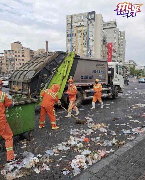 图为大连夜市开放后，地面一片狼藉，环卫工人清扫路面