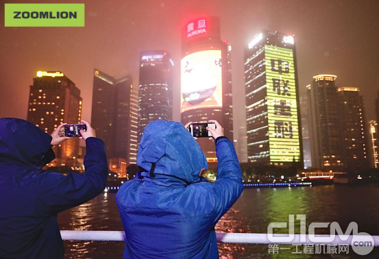 来宾们用手机拍摄黄浦江两岸夜景