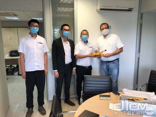 范鹏(右二)团队向巴西客户赠送徐工掘进机模型