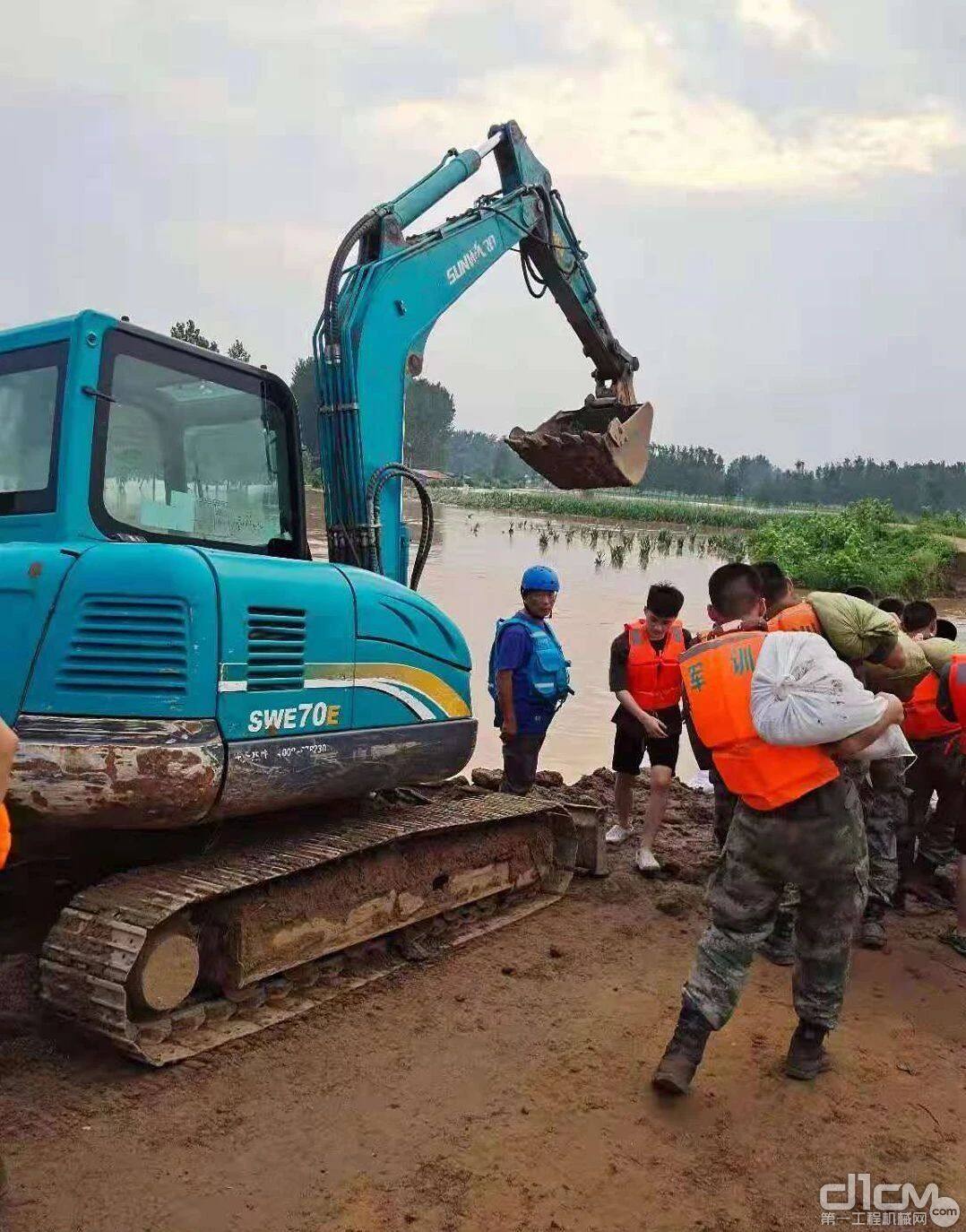 封堵决口的大堤上，山河智能装备协助一线救援人员作业。