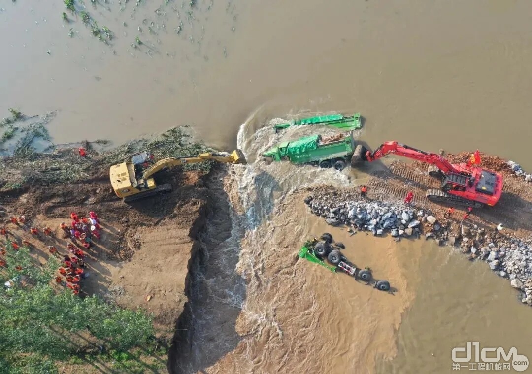 7月25日，满载石料的重型卡车被推入卫河鹤壁市浚县新镇镇彭村段的决口处(无人机照片)。新华社记者 张浩然 摄