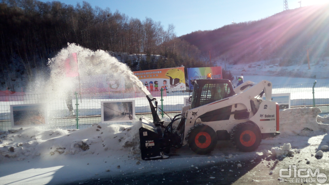 山猫滑移装载机搭载吹雪机除雪作业现场