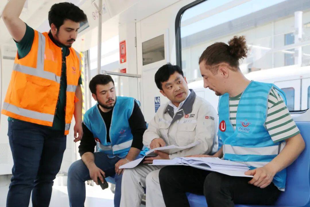 中车株机公司售后服务队员魏功益（左二）与土耳其人员交流车辆技术信息。（张灿强 摄影）