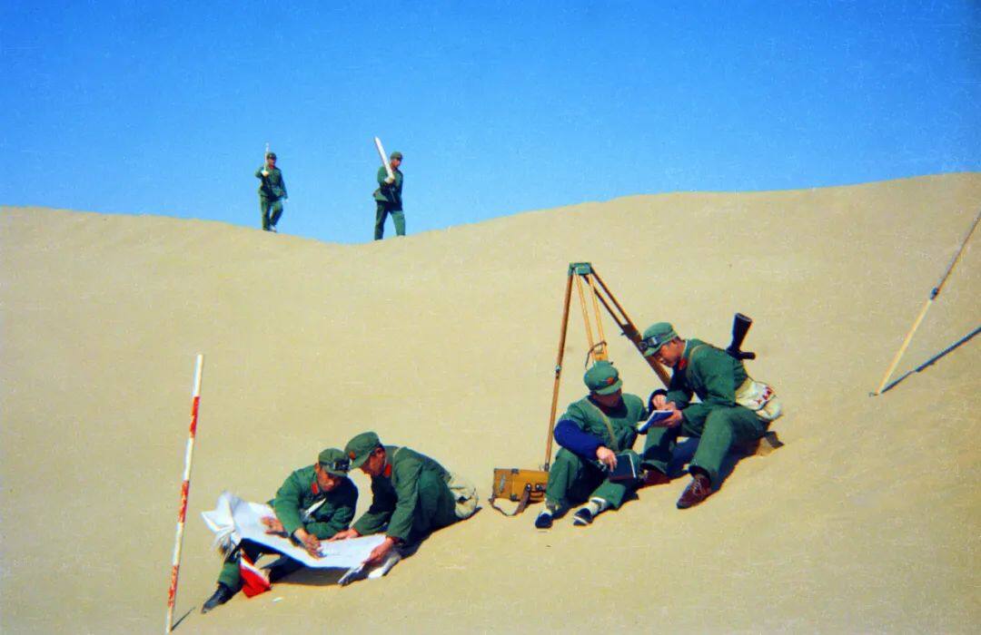 修建南疆铁路时铁道兵测量战士在天山脚下的风口沙漠地带作业