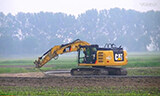 卡特彼勒323E挖掘机在农田铺设水管